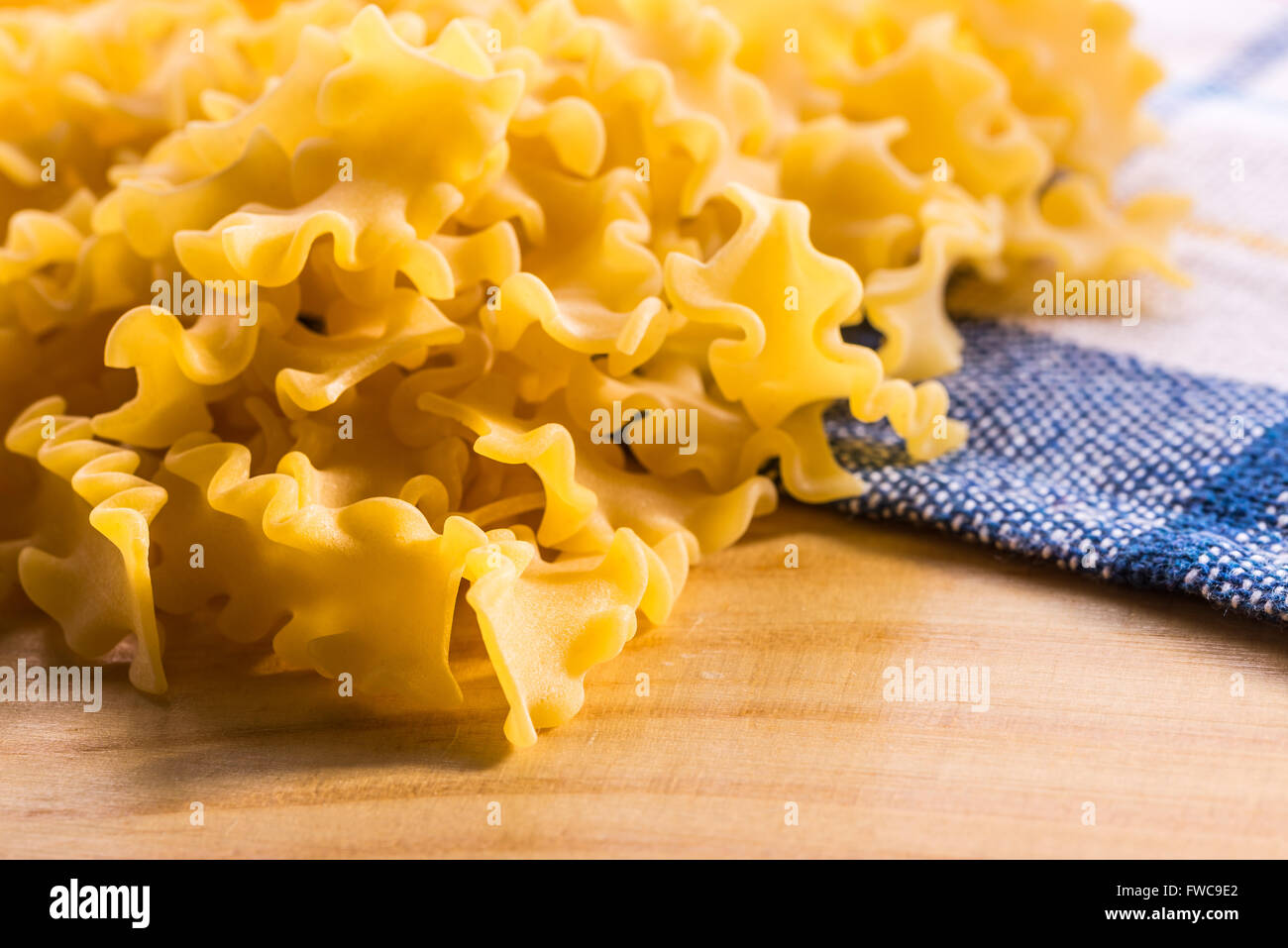 Close up di pasta italiana, Mafalda corta, su di un tavolo di legno Foto Stock
