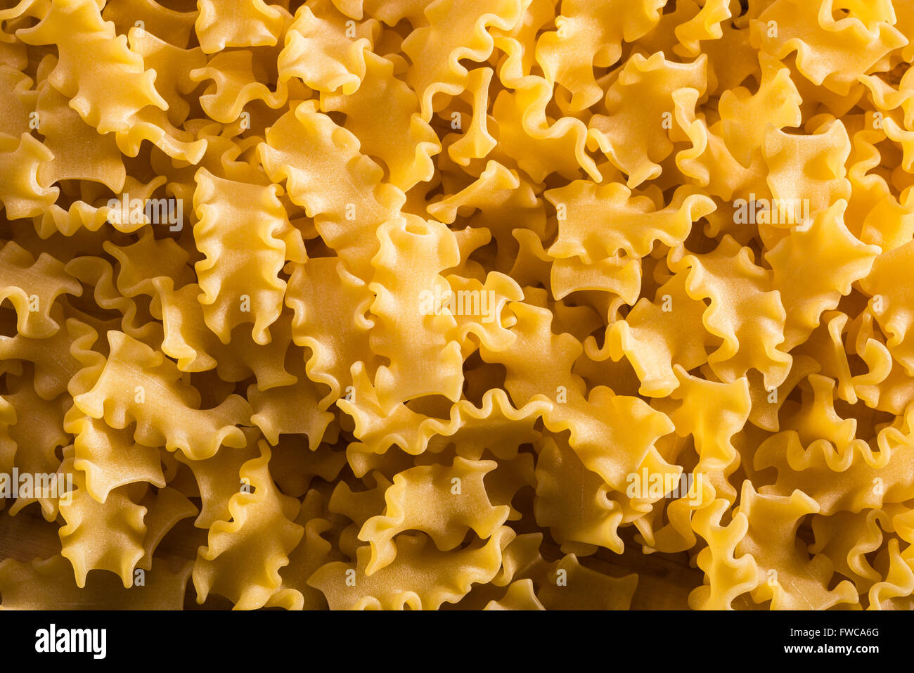 Close up di pasta italiana, Mafalda corta, su di un tavolo di legno Foto Stock