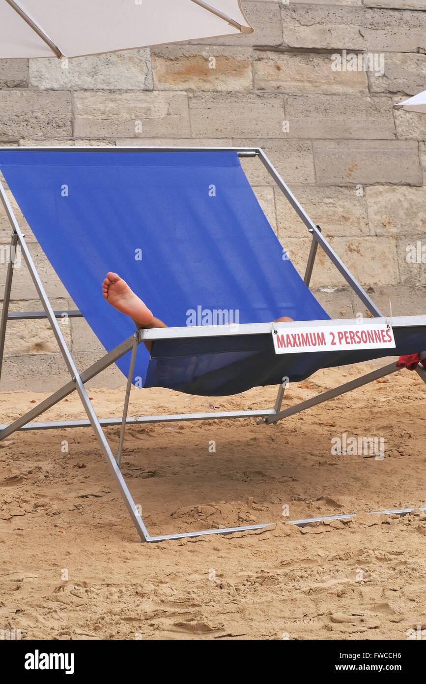 Una donna si rilassa in una gigantesca struttura di poltrona sdraio su Paris Plage a Parigi Foto Stock
