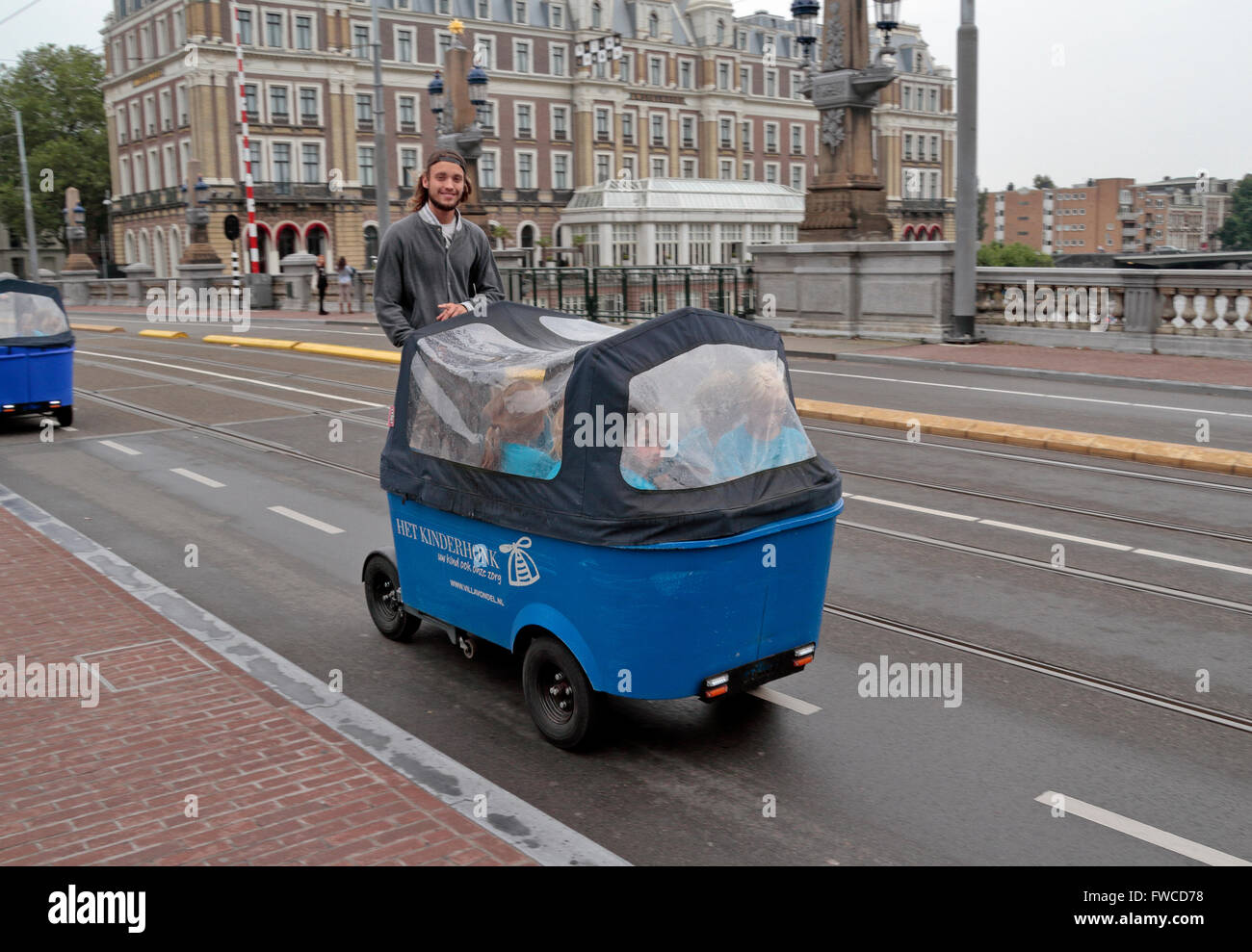 I bambini di essere trasportati in un elettrico alimentato carro chiamato un Segway bakfiet in Amsterdam, Paesi Bassi. Foto Stock