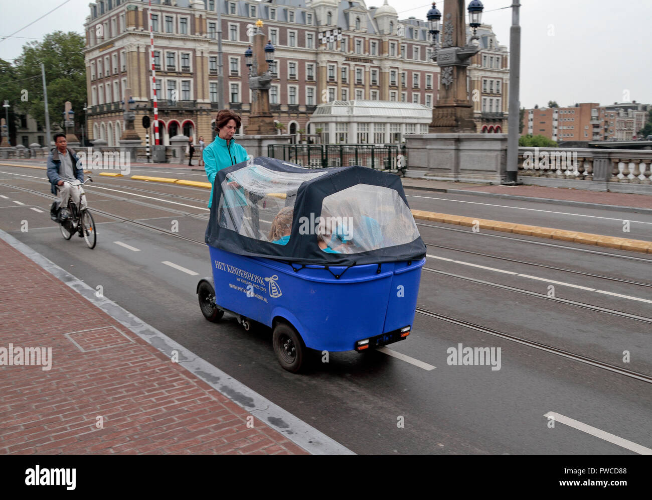 I bambini di essere trasportati in un elettrico alimentato carro chiamato un Segway bakfiet in Amsterdam, Paesi Bassi. Foto Stock