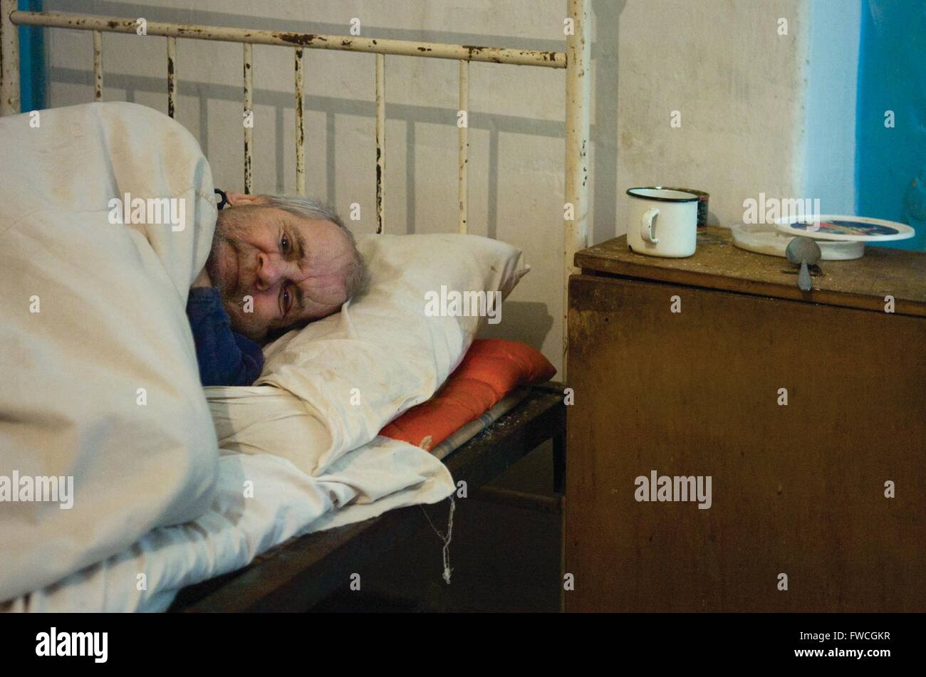 Didivschyna, Ucraina. Residente presso il governo eseguire la casa di cura prevede nel suo letto. Foto Stock