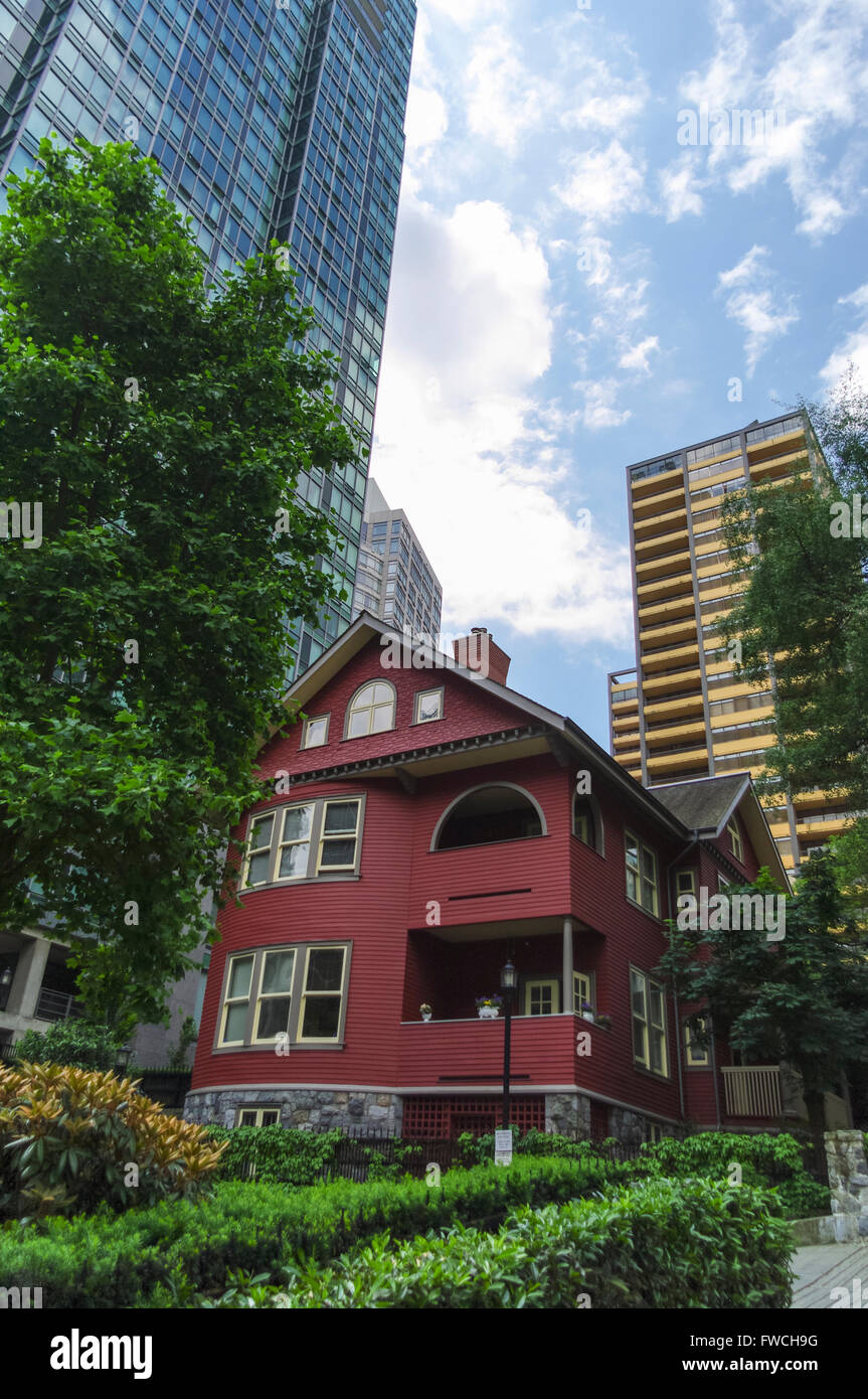 Piccola casa vecchia sia offuscato da un alto e moderno edificio in Vancouver, British Columbia, Canada. Foto Stock