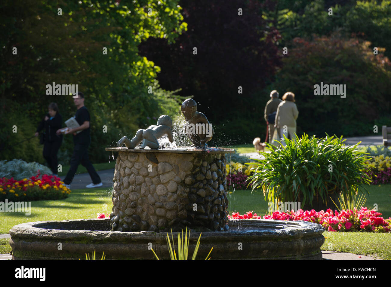 Giardini della valle, Harrogate, nello Yorkshire, Inghilterra - bella, soleggiato parco con fontana, aiuole fiorite e 4 persone e rilassanti passeggiate. Foto Stock