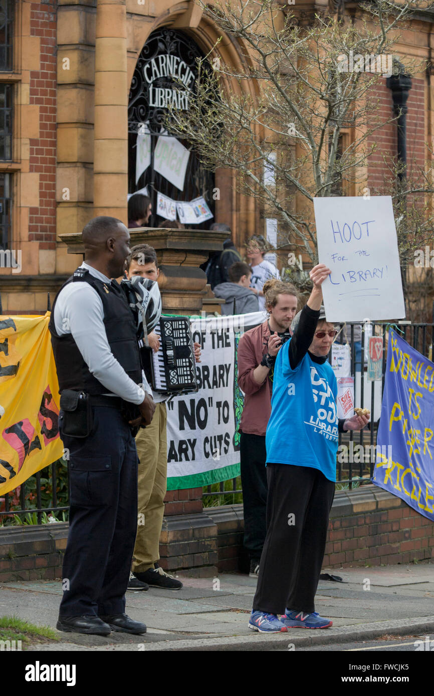 Londra, Regno Unito. 03 apr, 2016. Un diruttore invita gli automobilisti a spasso il loro sostegno per il chiusi di recente biblioteca Carnegie dal consiglio di Lambeth a Herne Hill, Londra del sud come occupanti rimangono all'interno dei locali del giorno 3 della sua occupazione, 3 aprile 2016. La collera della comunità locale in South London borough hanno occupato il loro importante risorsa per l apprendimento e il fulcro sociale per il weekend. Credito: RichardBaker/Alamy Live News Foto Stock