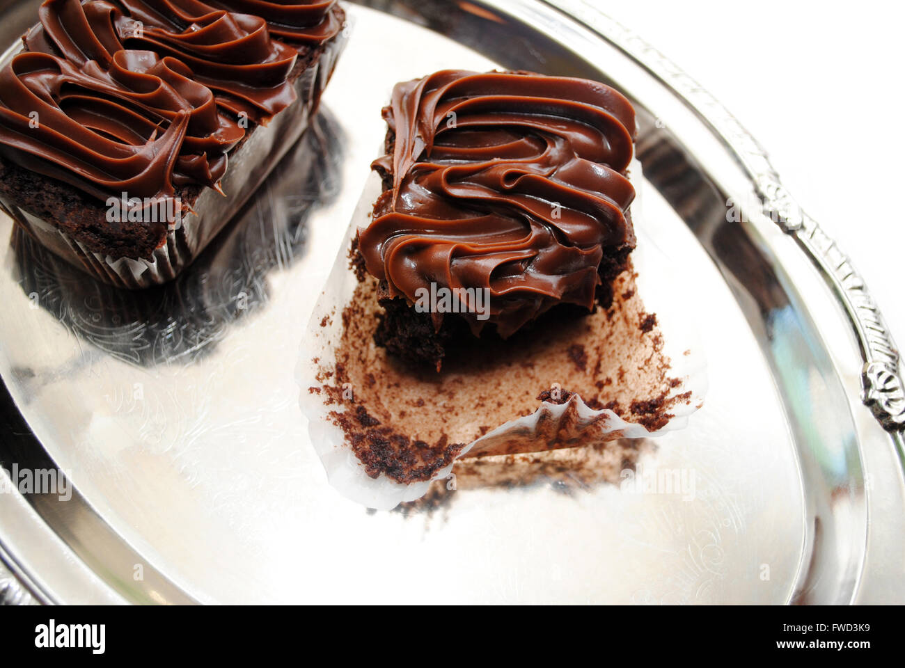 Mangiare una tripla Brownie al cioccolato su un piatto d'Argento Foto Stock