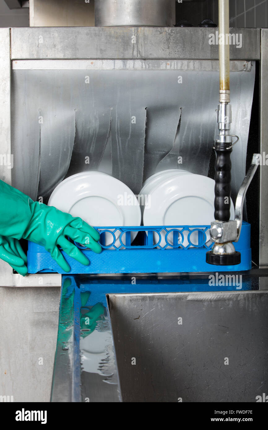 Grande cucina industriale lavastoviglie e lavandino tutti in acciaio inox Foto Stock