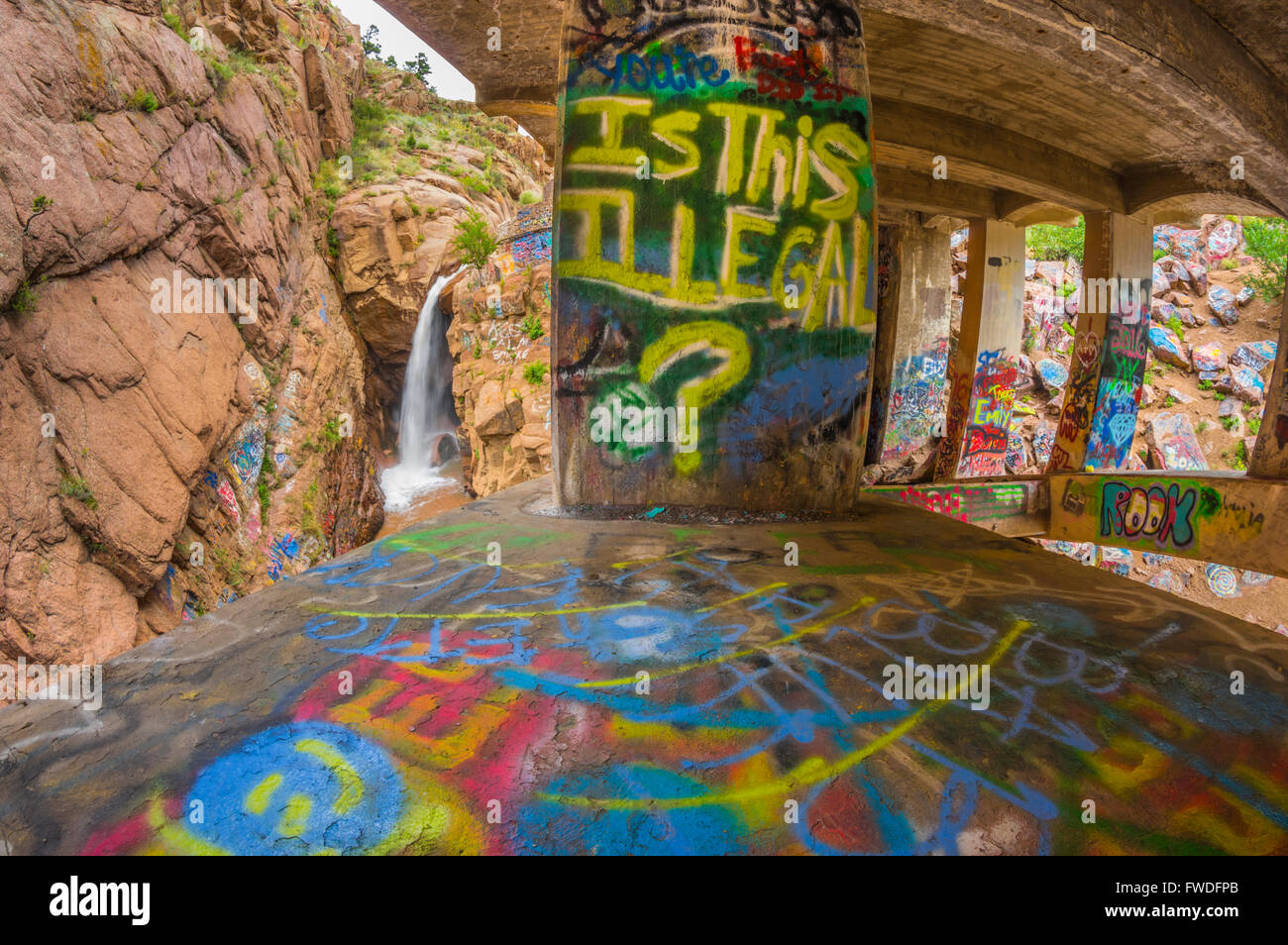 Verniciato a spruzzo graffiti sotto un ponte a Rainbow Falls in Manitou Springs, Colorado. Foto Stock