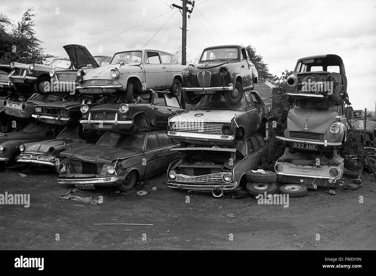 Vecchia auto automobili impilati scrapyard Gran Bretagna 1975 Foto Stock