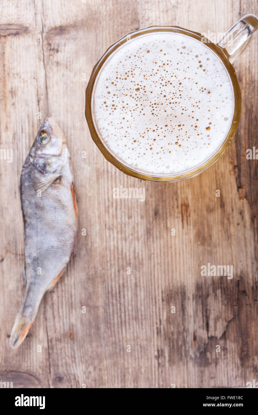 La birra e il pesce sulla tavola di legno verticale in alto consente di visualizzare lo sfondo Foto Stock