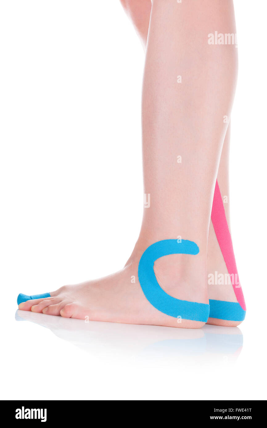 Tape terapeutico sul piede femminile isolato su sfondo bianco. Il dolore cronico, medicina alternativa. Riabilitazione e Fisioterapia Foto Stock