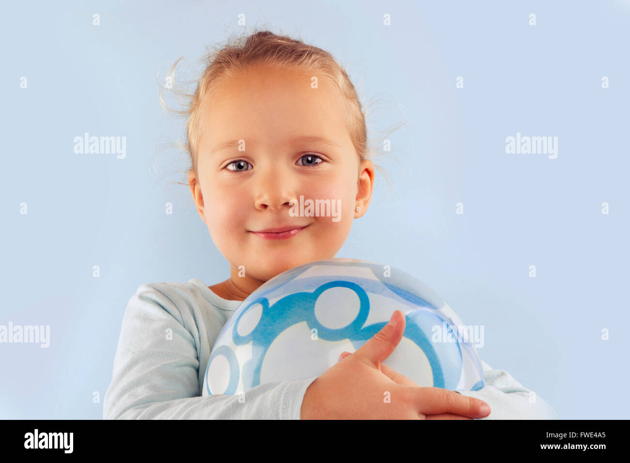 L'estate. Adorabili e bellissima ragazza con sfera contro sfondo blu. Estate sfondo. Foto Stock
