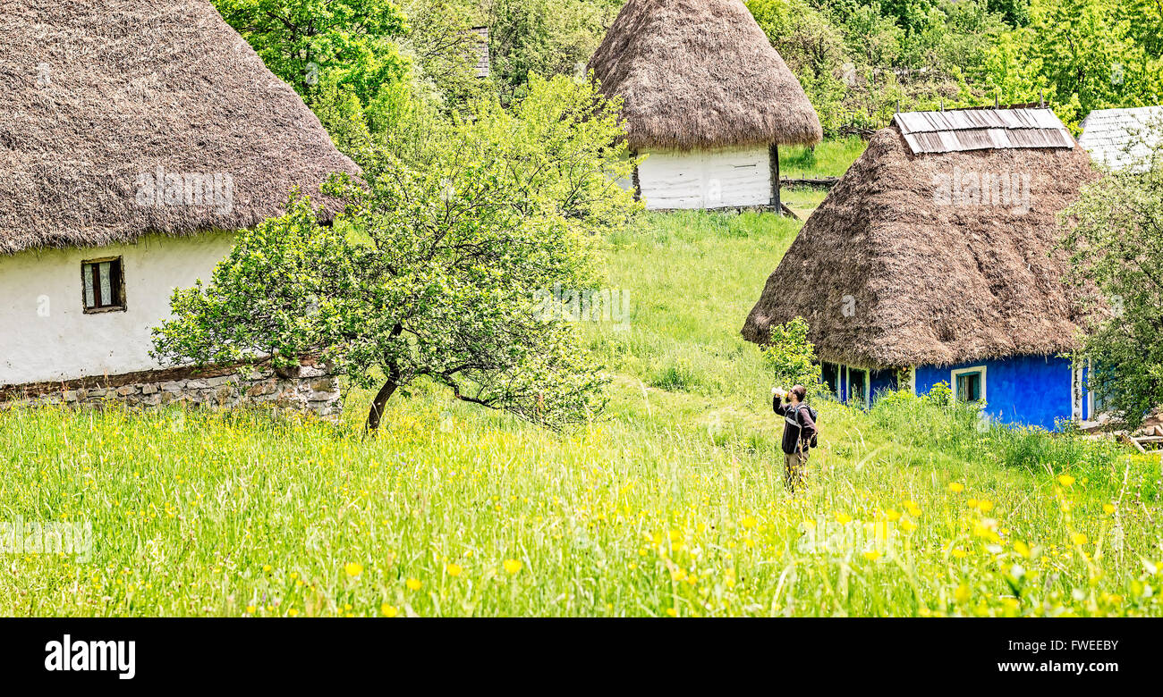 Uomo con barba, occhiali da sole e zainetto acqua potabile circondata da antiche case Foto Stock