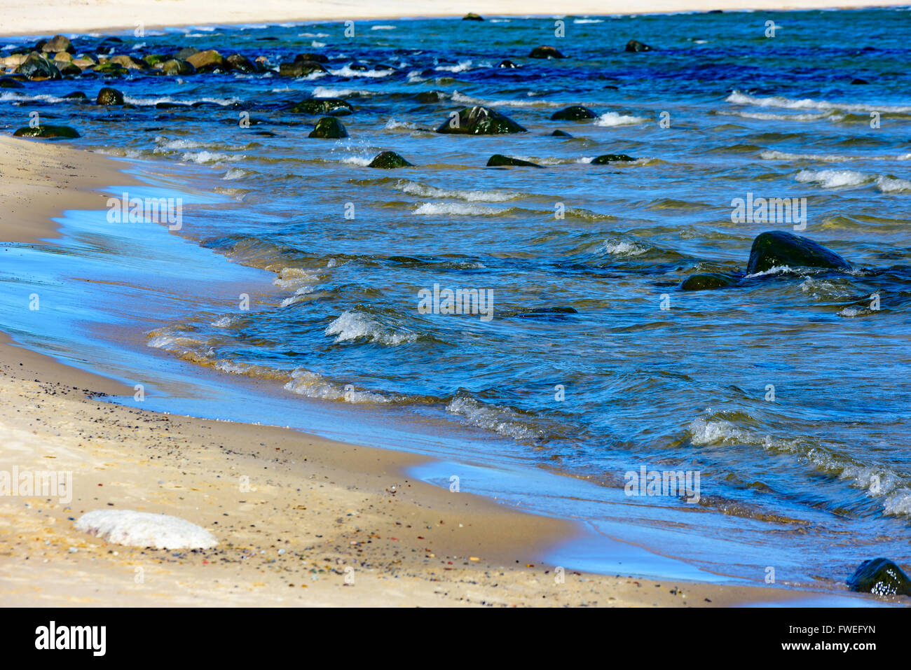 La brezza è monta su certi bianchi al mare presso la spiaggia in sabbia di Costa. Foto Stock