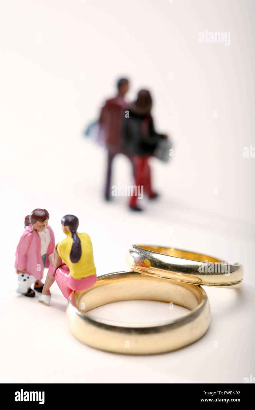 Concetto di immagine di una donna sat su anelli di nozze di parlare ad un bambino per illustrare il divorzio gli effetti sui bambini Foto Stock