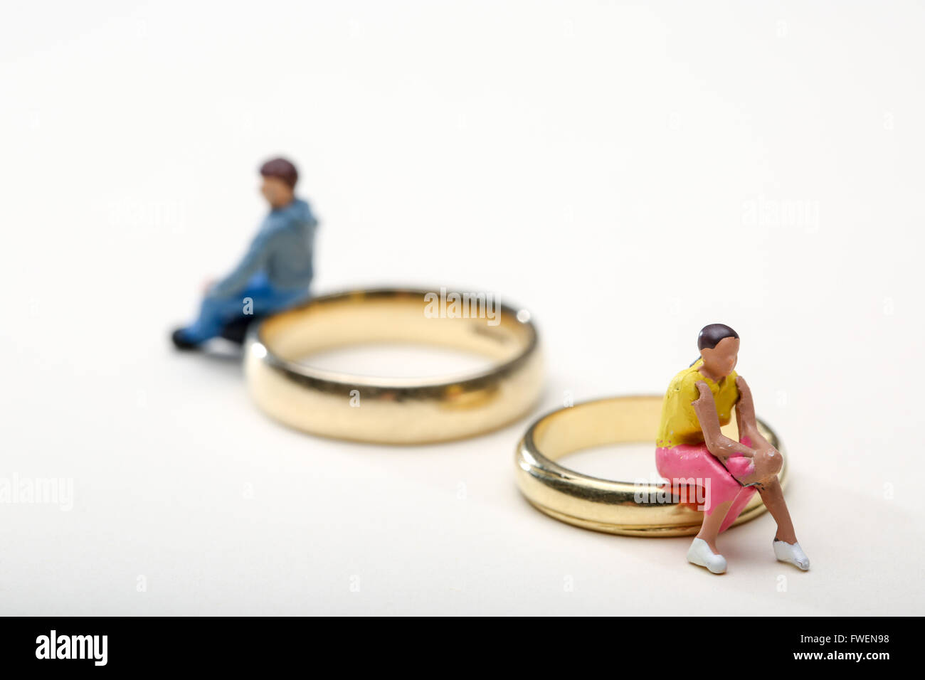 Concetto di immagine di un giovane seduto su anelli di nozze per illustrare il divorzio e la separazione Foto Stock