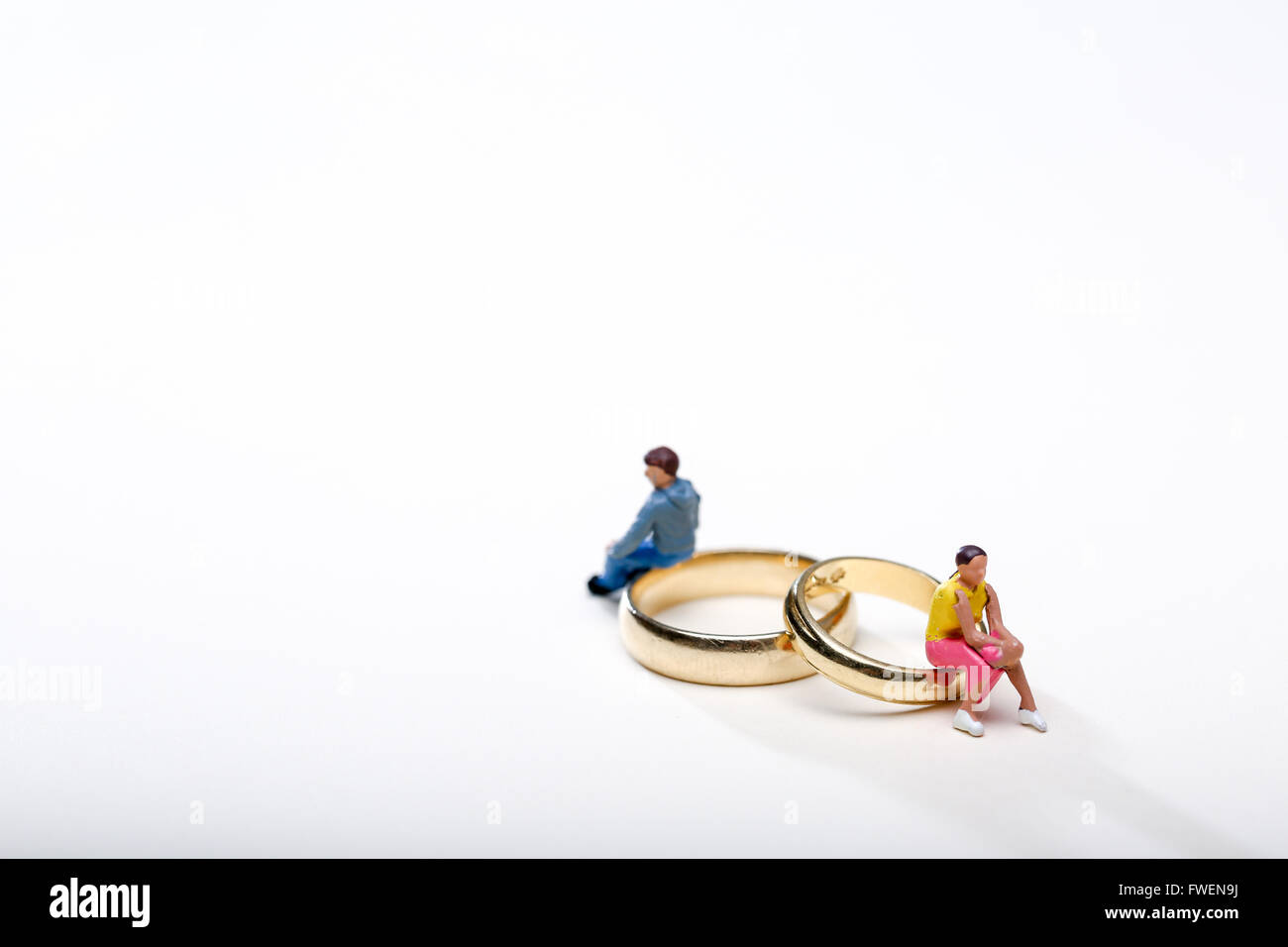 Concetto di immagine di un giovane seduto su anelli di nozze per illustrare il divorzio e la separazione Foto Stock