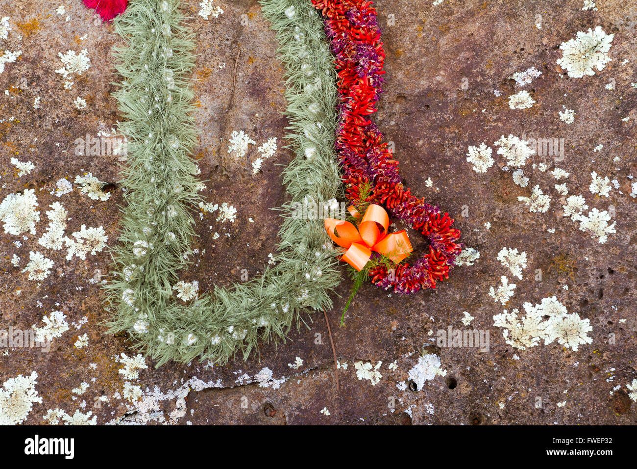 Questi bellissimi fiori leis sono state collocate sulle pietre del parto in Hawaii sulla North Shore di Oahu. Queste rocce storico Foto Stock