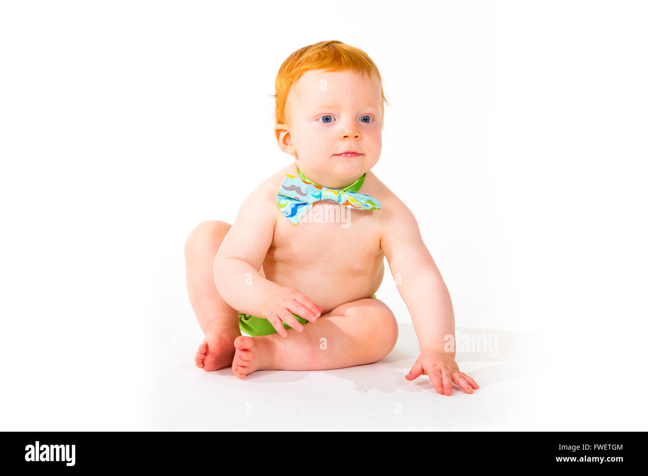Da un anno un bimbo in studio con uno sfondo bianco. Il ragazzo indossa una cravatta a farfalla e un pannolino. Foto Stock