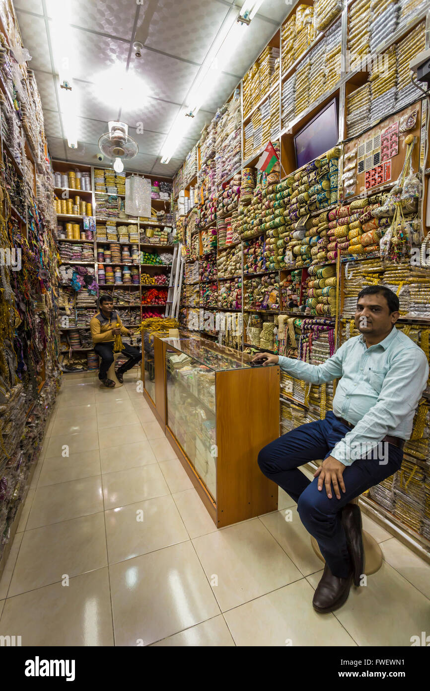 Seduti i negozianti in un negozio di brocade a Mutrah souq, Muscat Oman, Medio Oriente Foto Stock