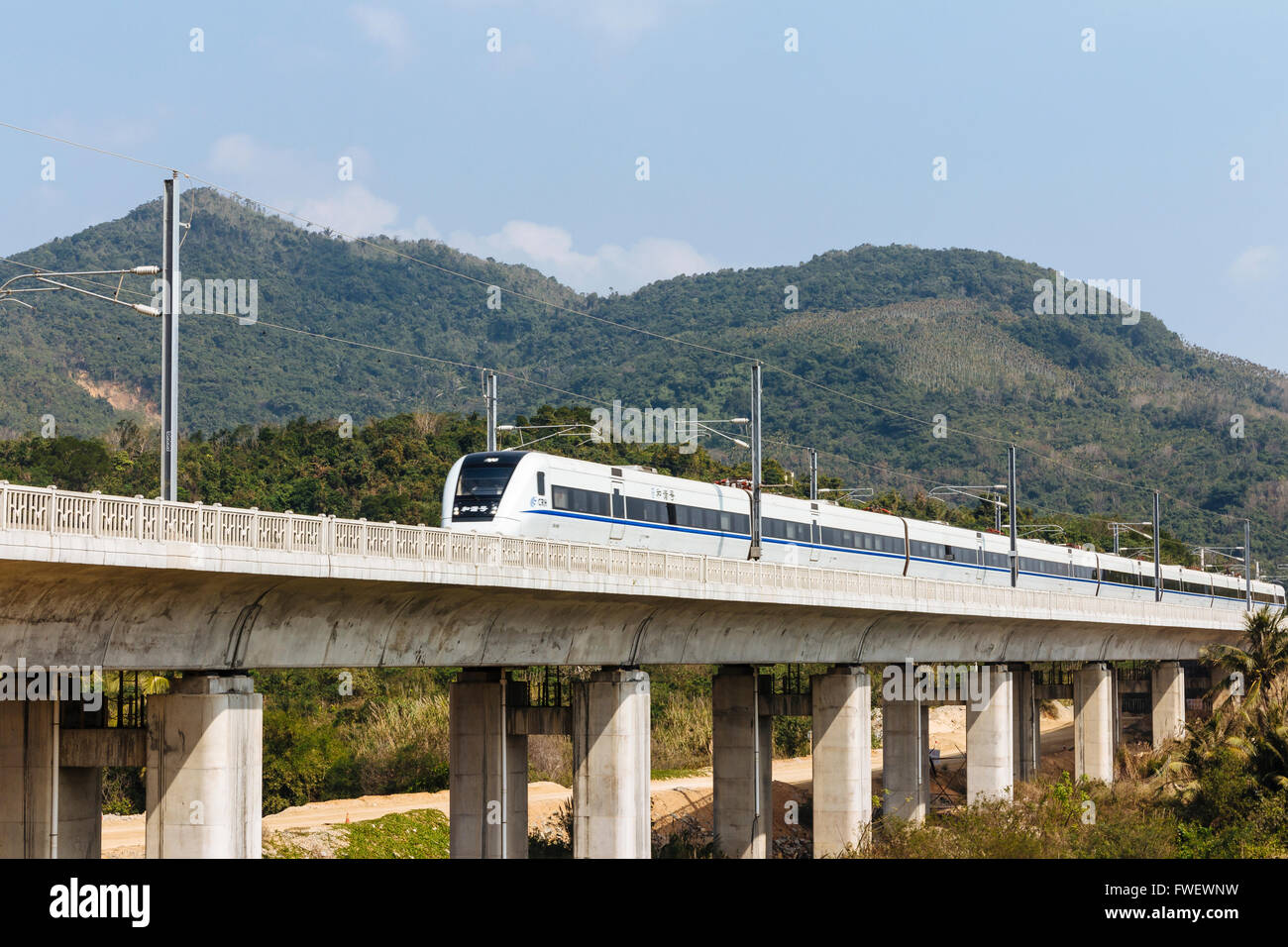 Hainan in Cina - La vista di treni ad alta velocità la guida passa da un viadotto nelle ore diurne. Foto Stock
