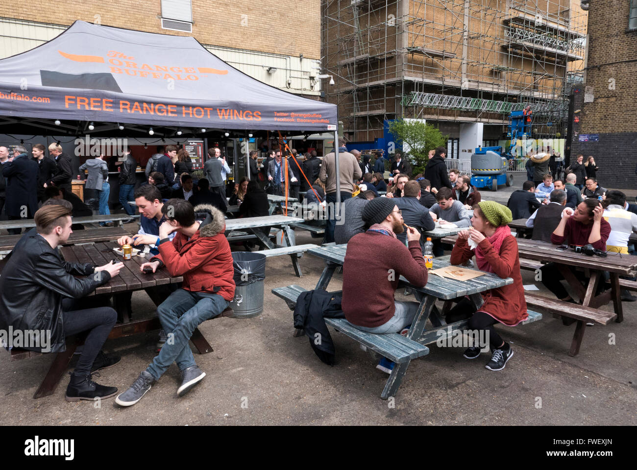 Persone mangiare fast food e di bere in un ristorante all'aperto a Londra, Regno Unito. Foto Stock