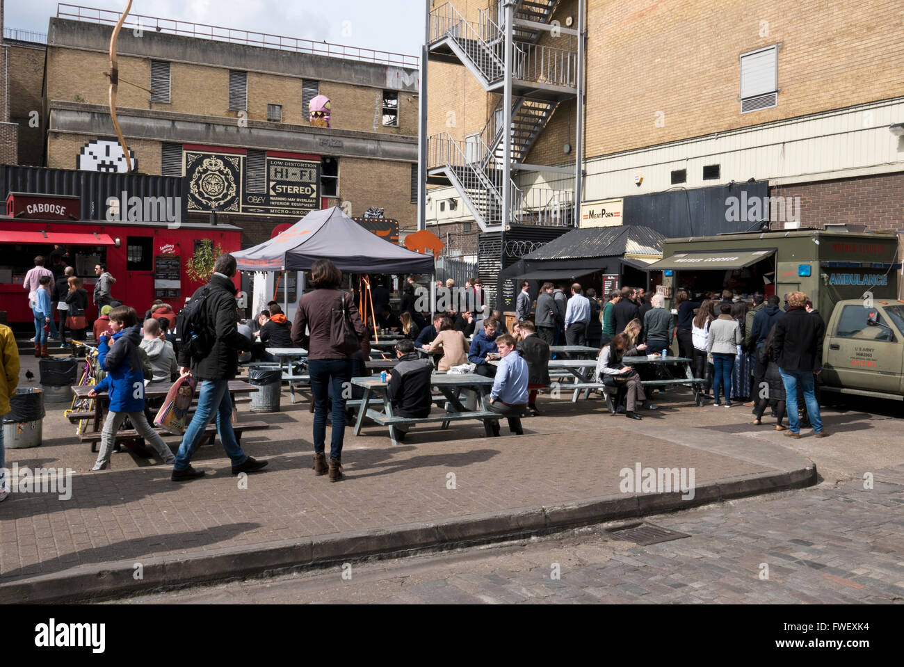 Persone mangiare fast food e di bere in un ristorante all'aperto a Londra, Regno Unito. Foto Stock