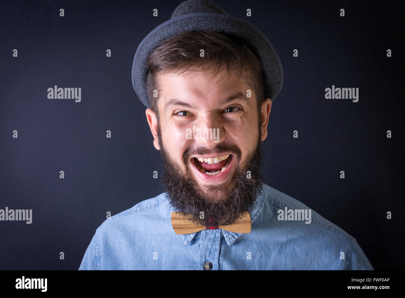 Arrabbiato uomo barbuto yealing in una maglietta blu Foto Stock