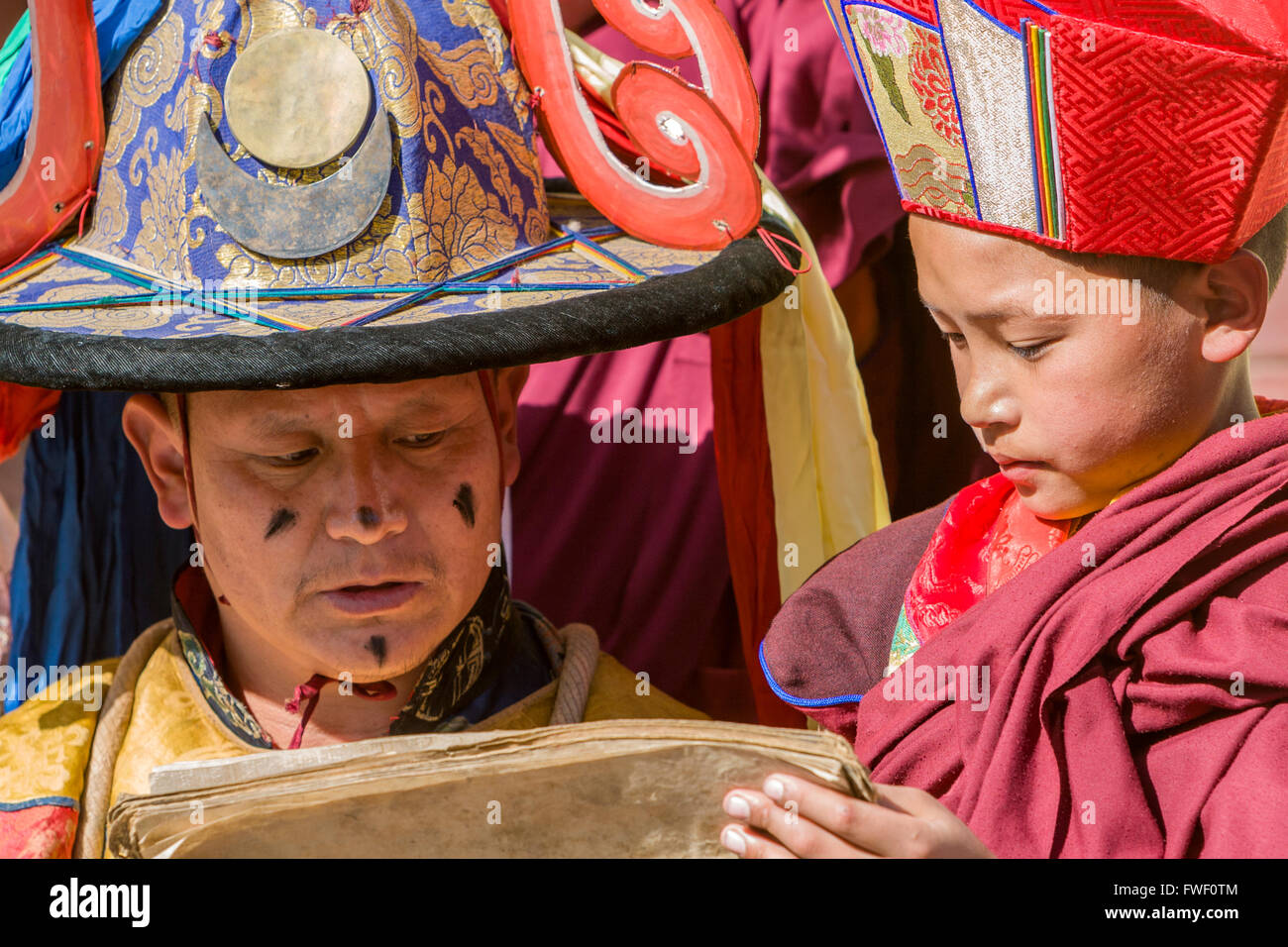 Il Nepal, Kathmandu, Swayambhunath. Giovane monaco novizio può contenere testo sacro mentre Monaco Senior di legge. Foto Stock
