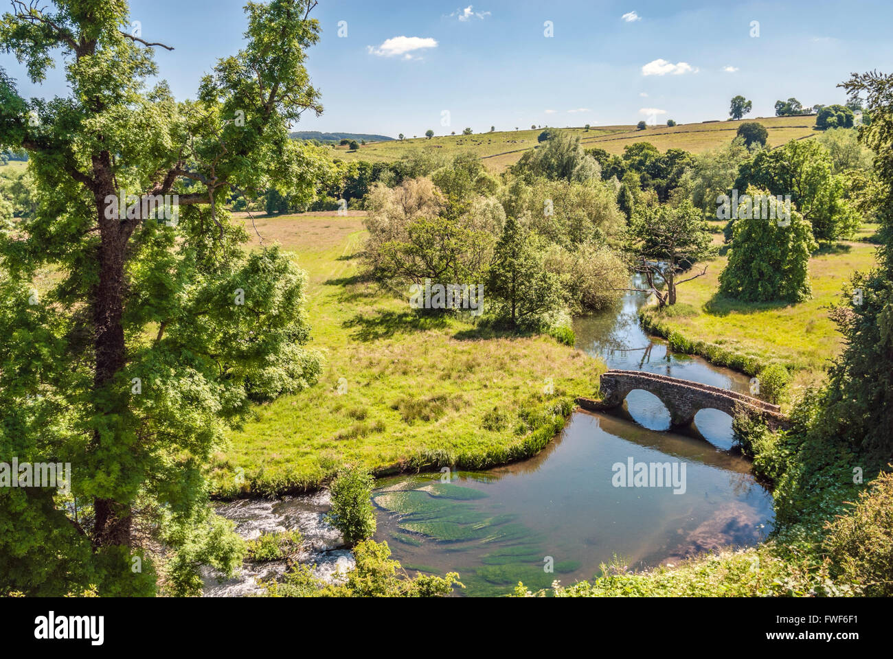Vista dal castello normanno Haddon Hall oltre la station wagon e il ponte che attraversa il fiume Wye vicino a Bakewell, nel centro dell'Inghilterra. Foto Stock