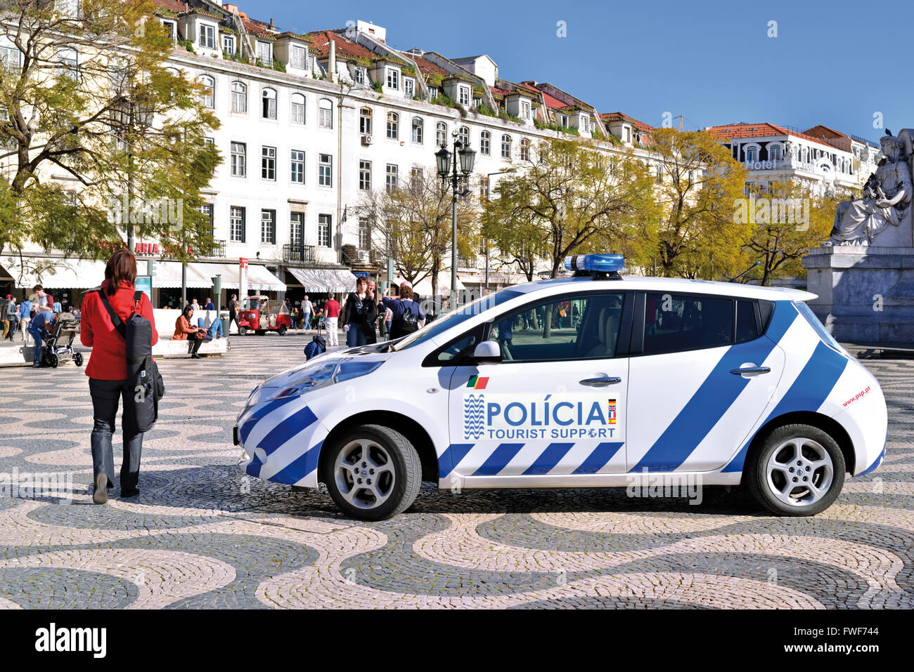 Il Portogallo, Lisbona: Donna passando un supporto turistico auto della polizia a Rossio Foto Stock