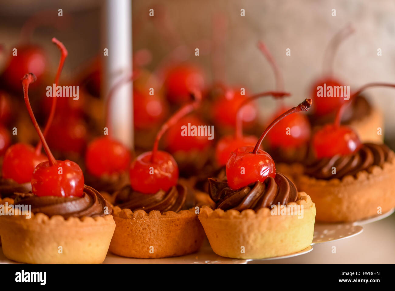 Tortini di cioccolato con la ciliegia sulla parte superiore Foto Stock