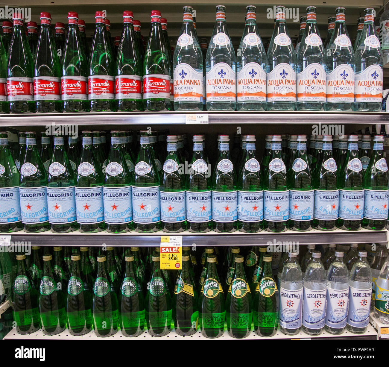 File di nomi di marca scintillanti acque in bottiglia su drogheria ripiani. Foto Stock