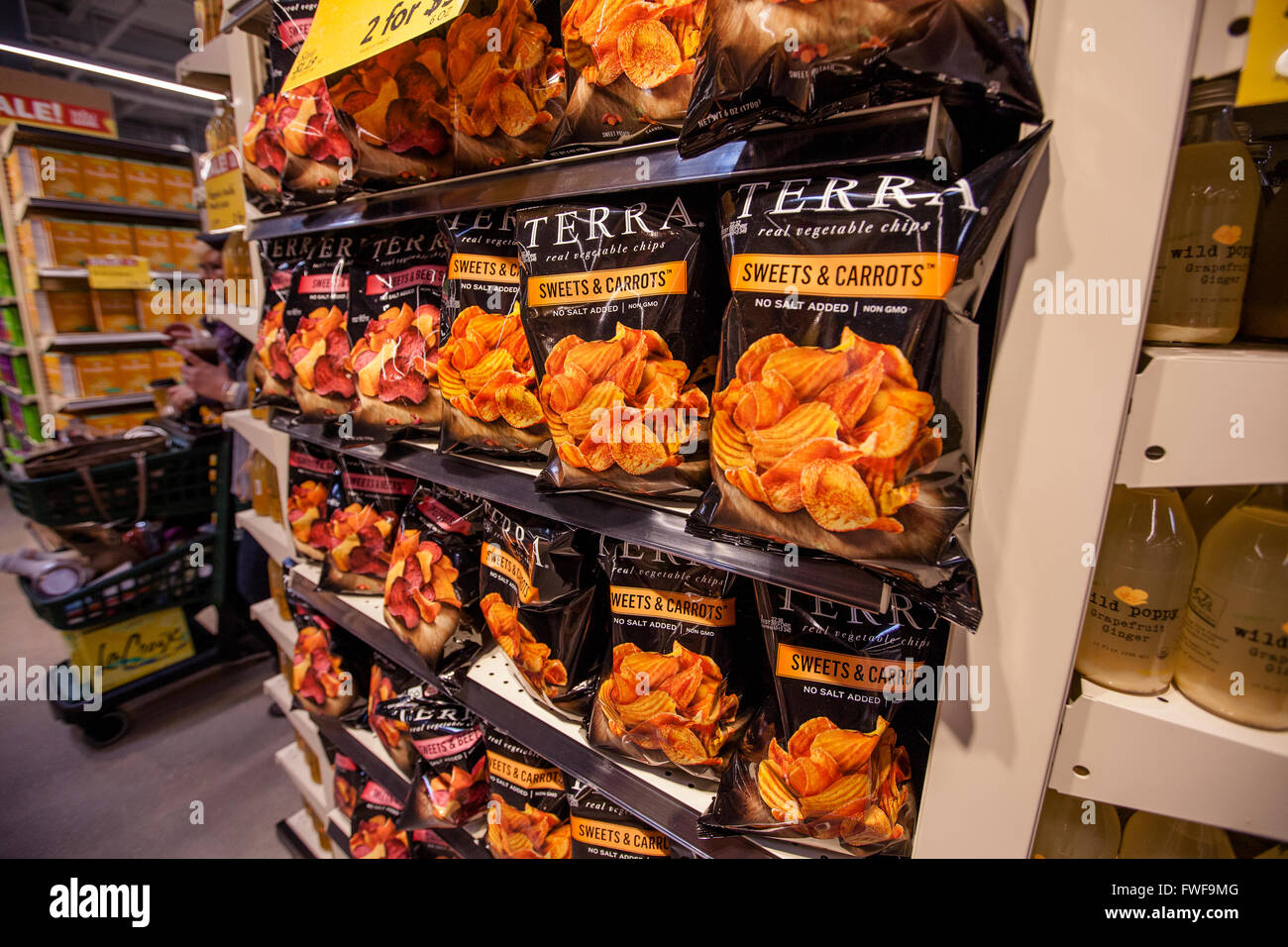 Sacchetti di Terra di marca snack vegetale impilati su ripiani in un negozio di alimentari Foto Stock