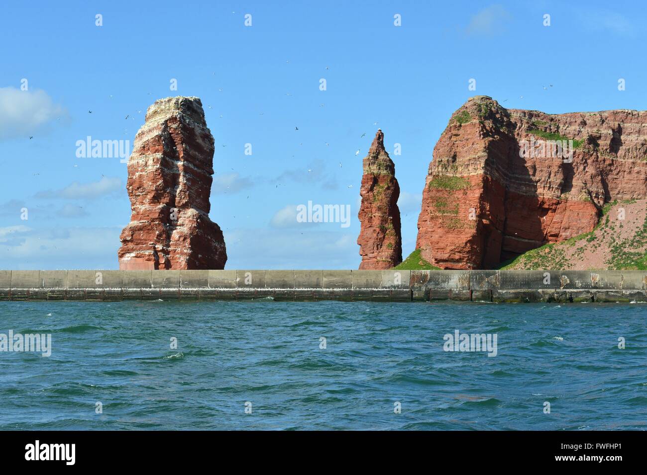 Helgoland distintivo della Lange Anna e altre rocce dietro una protezione di parete in calcestruzzo, 27 aprile 2015 Foto Stock