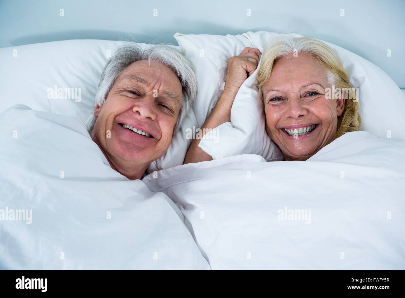 Ritratto di Allegro coppia senior di dormire sul letto Foto Stock