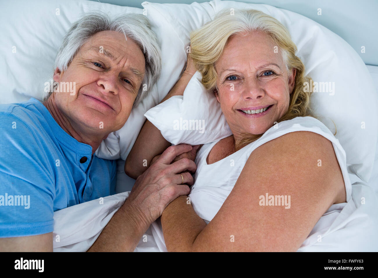 Ritratto di Allegro pensionato giovane rilassante sul letto Foto Stock