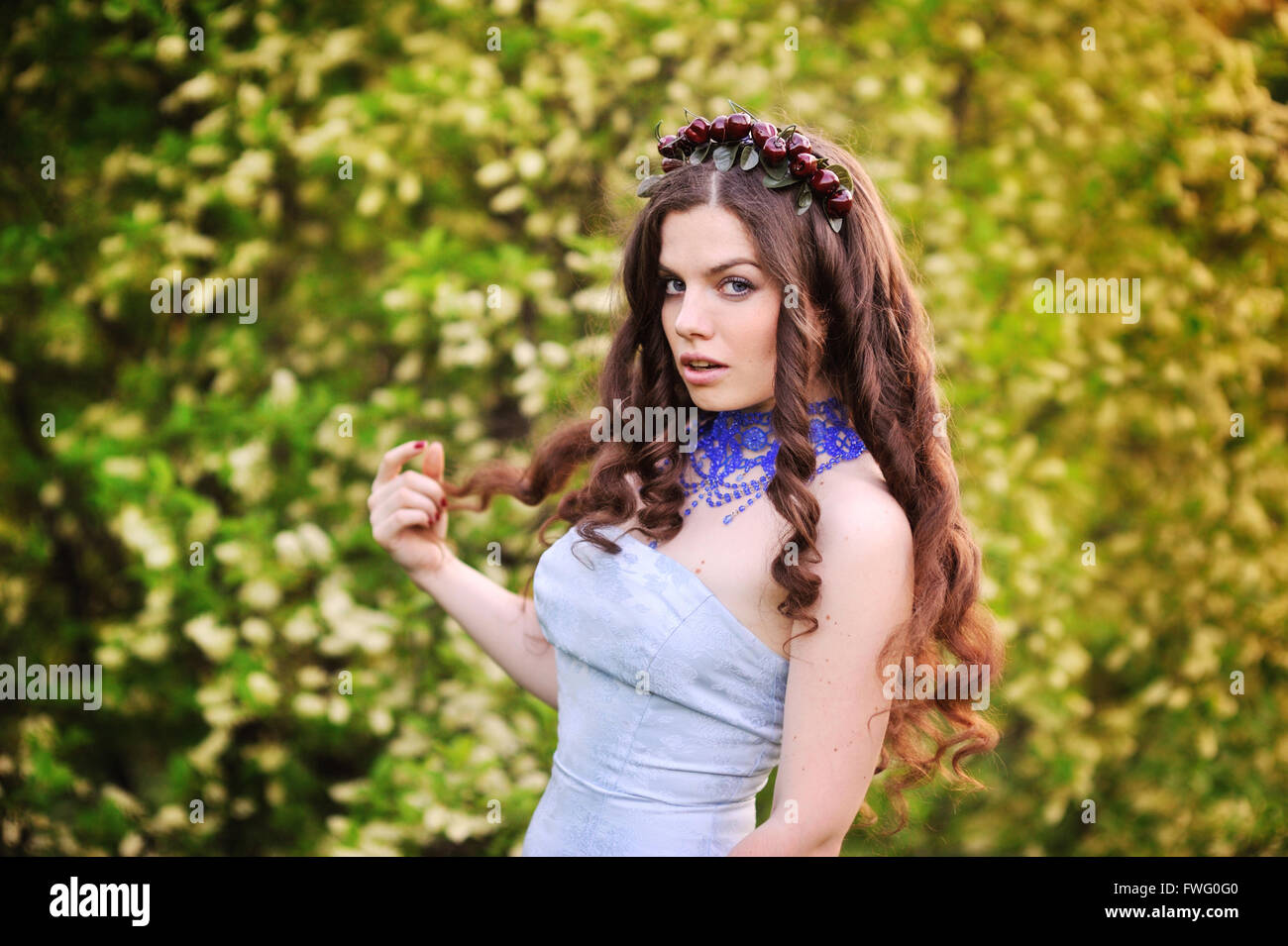 Bella ragazza in giardino con alberi di ciliegio Foto Stock