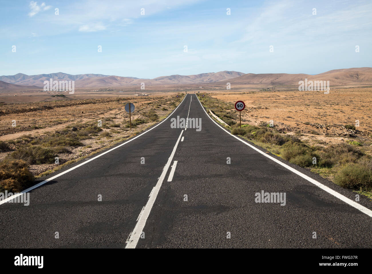 Dritto su strada asfaltata attraversando il deserto, Fuerteventura, Isole Canarie, Spagna Foto Stock