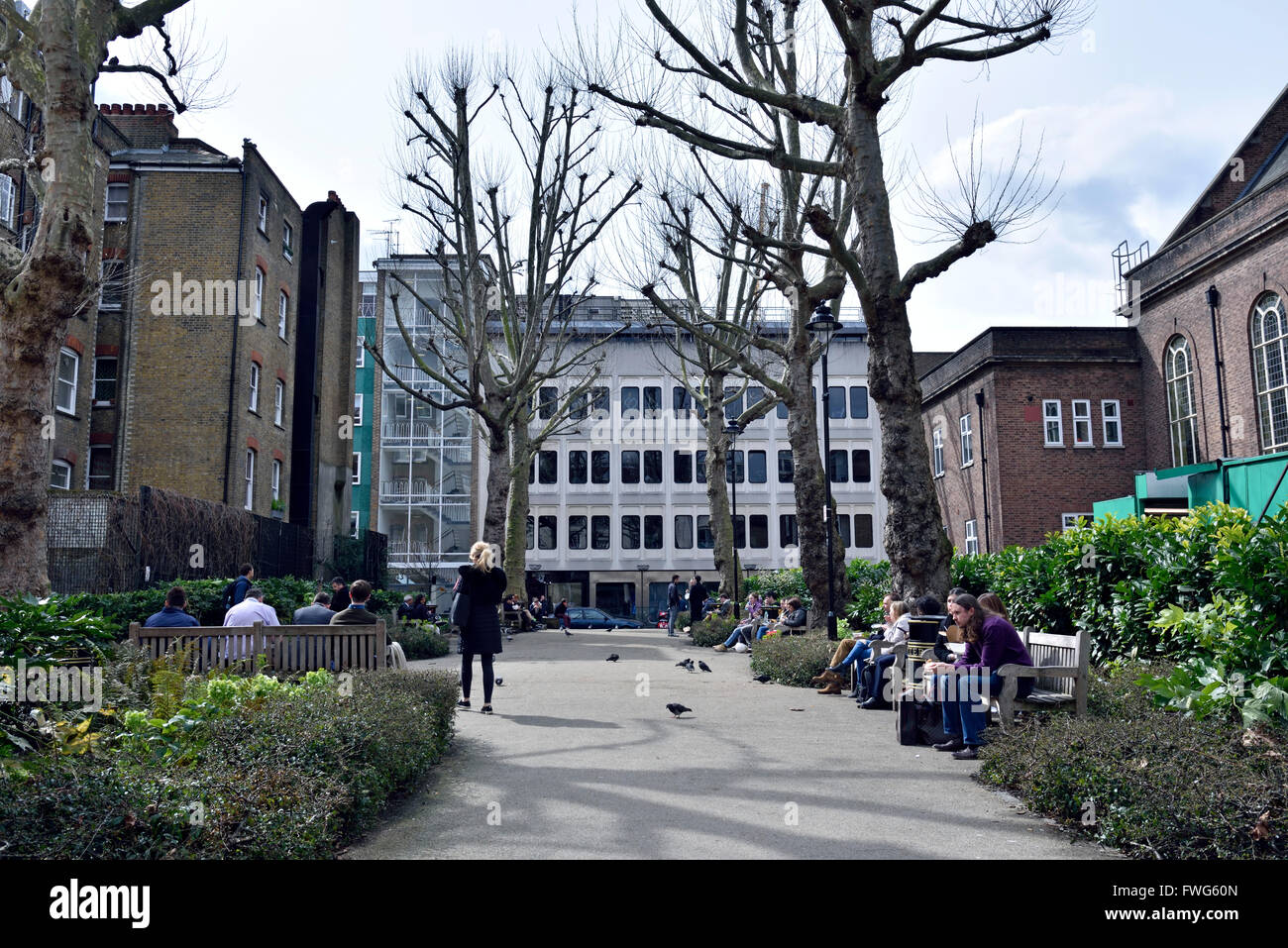 La gente seduta sulle panchine in giardino pubblico fuori Tottenham Court Road, London Borough of Camden Inghilterra Gran Bretagna REGNO UNITO Foto Stock