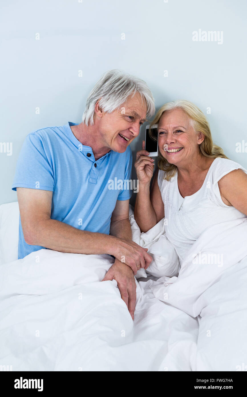 Felice coppia in pensione ascoltare musica tramite smartphone Foto Stock