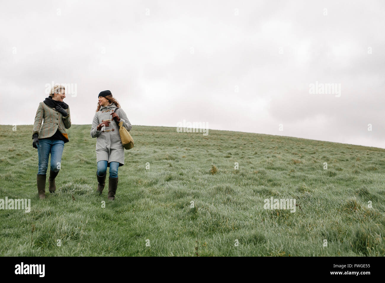 Due donne camminare sull'erba. Foto Stock