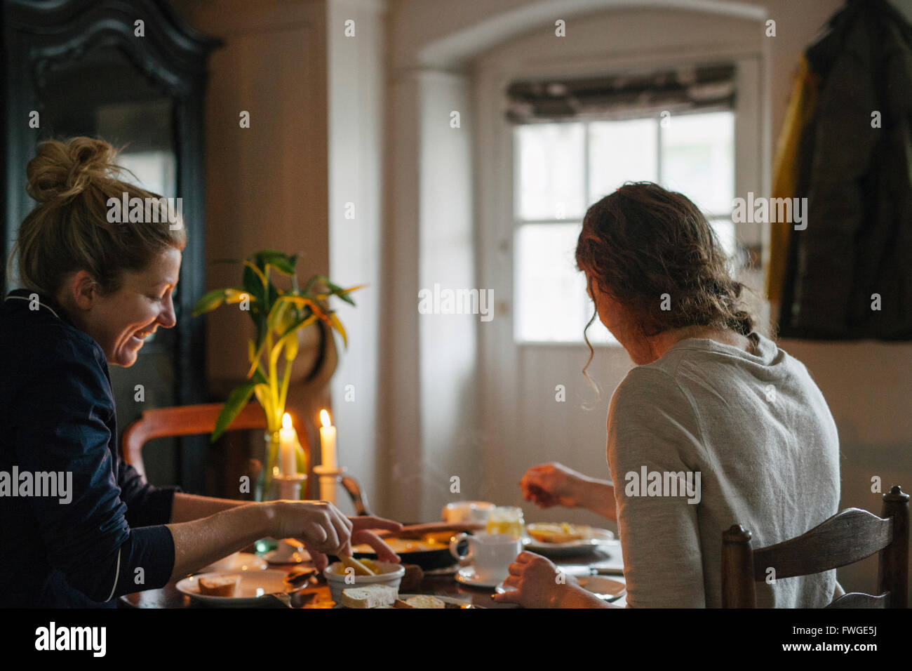 Due donne sedute a un tavolo avente una cena a lume di candela. Foto Stock