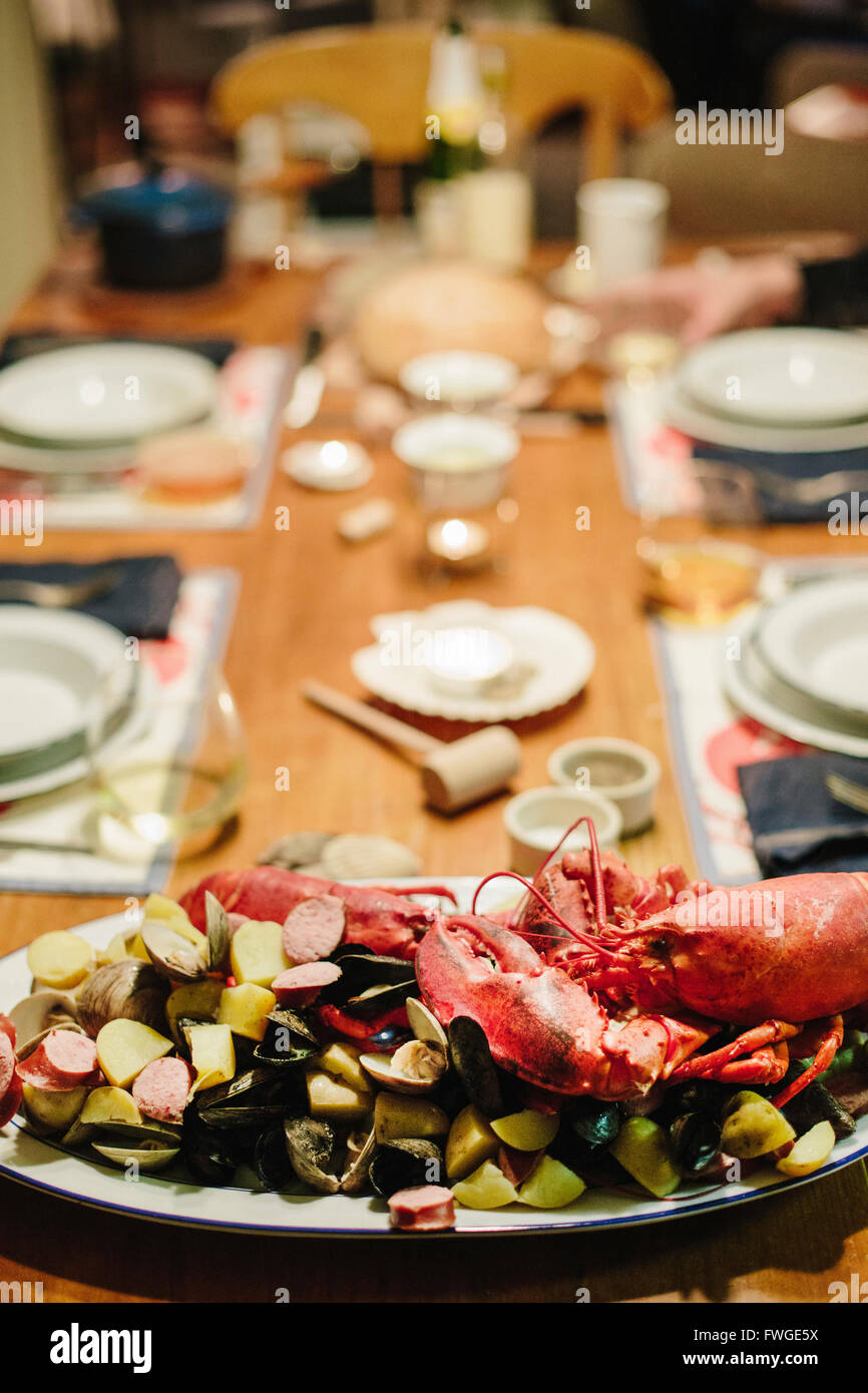 Una tabella di cui per un pasto, un piatto di frutti di mare con astice e vongole. Foto Stock