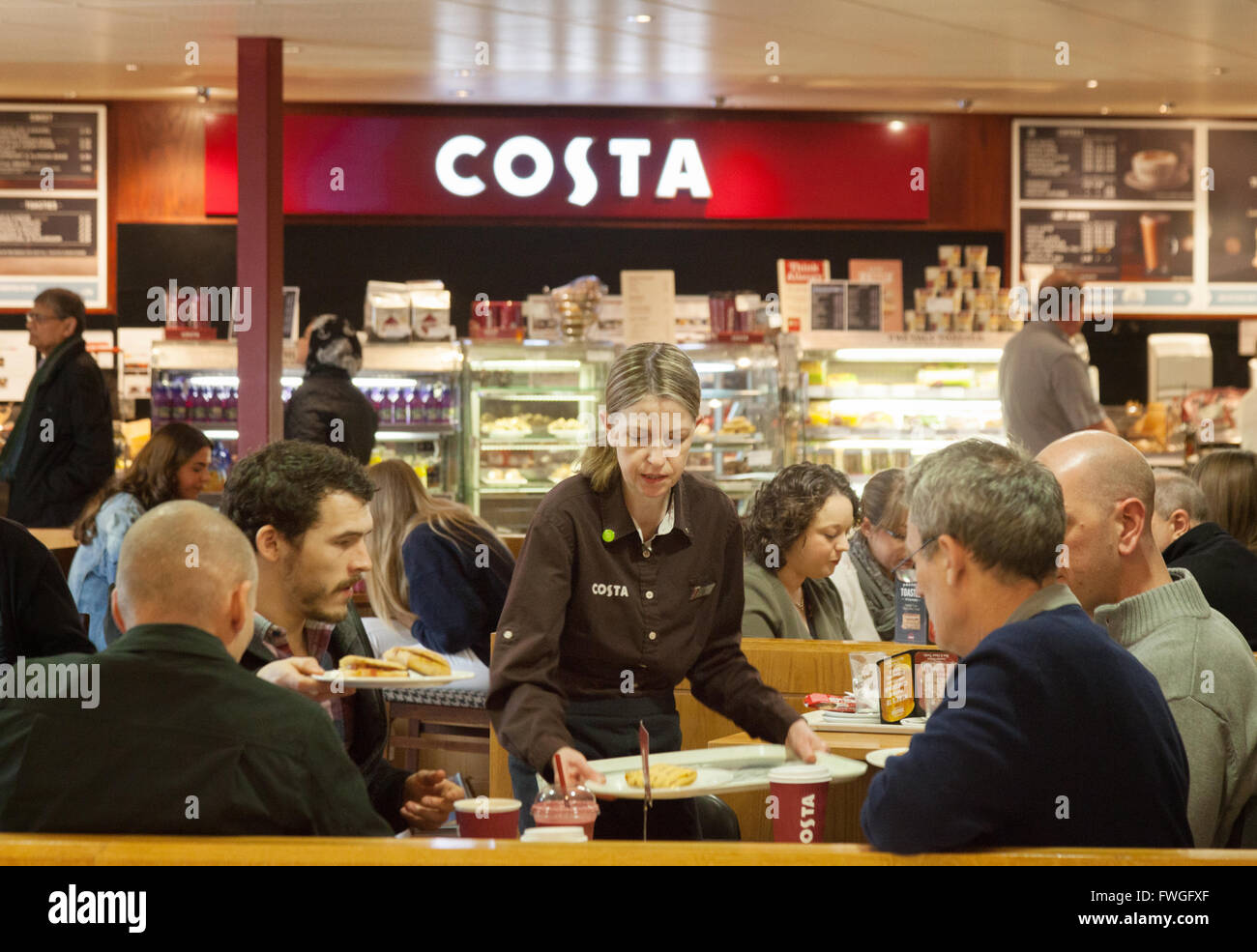Costa Coffee cameriera personale che serve caffè e cibo, Costa Coffee, South Mimms stazione di servizio autostradale, M25, London REGNO UNITO Foto Stock