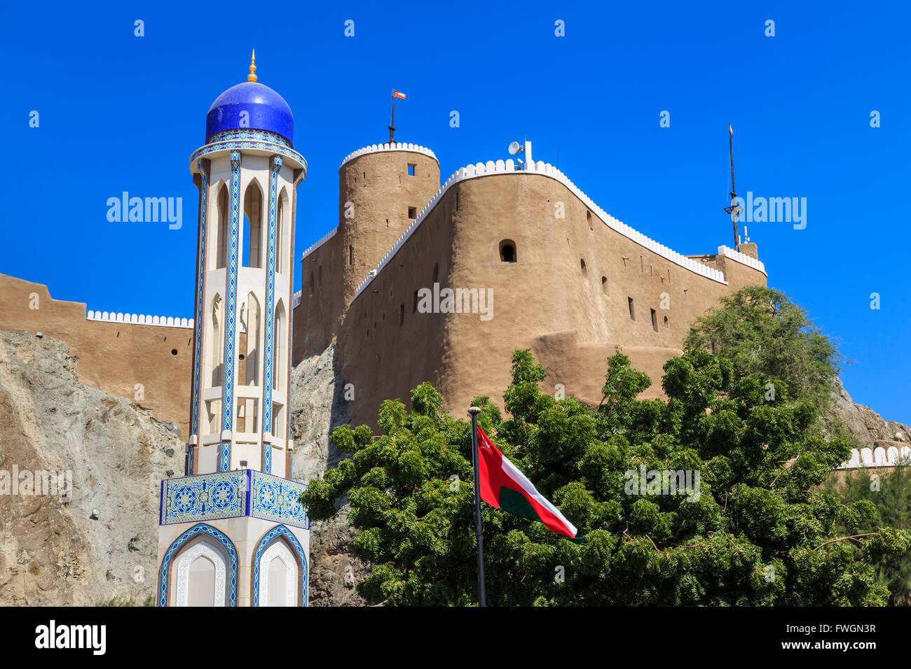 A cupola blu minareto della moschea, Oman, Medio Easti bandiera nazionale e Al-Mirani Fort, Old Muscat Oman, Medio Oriente Foto Stock