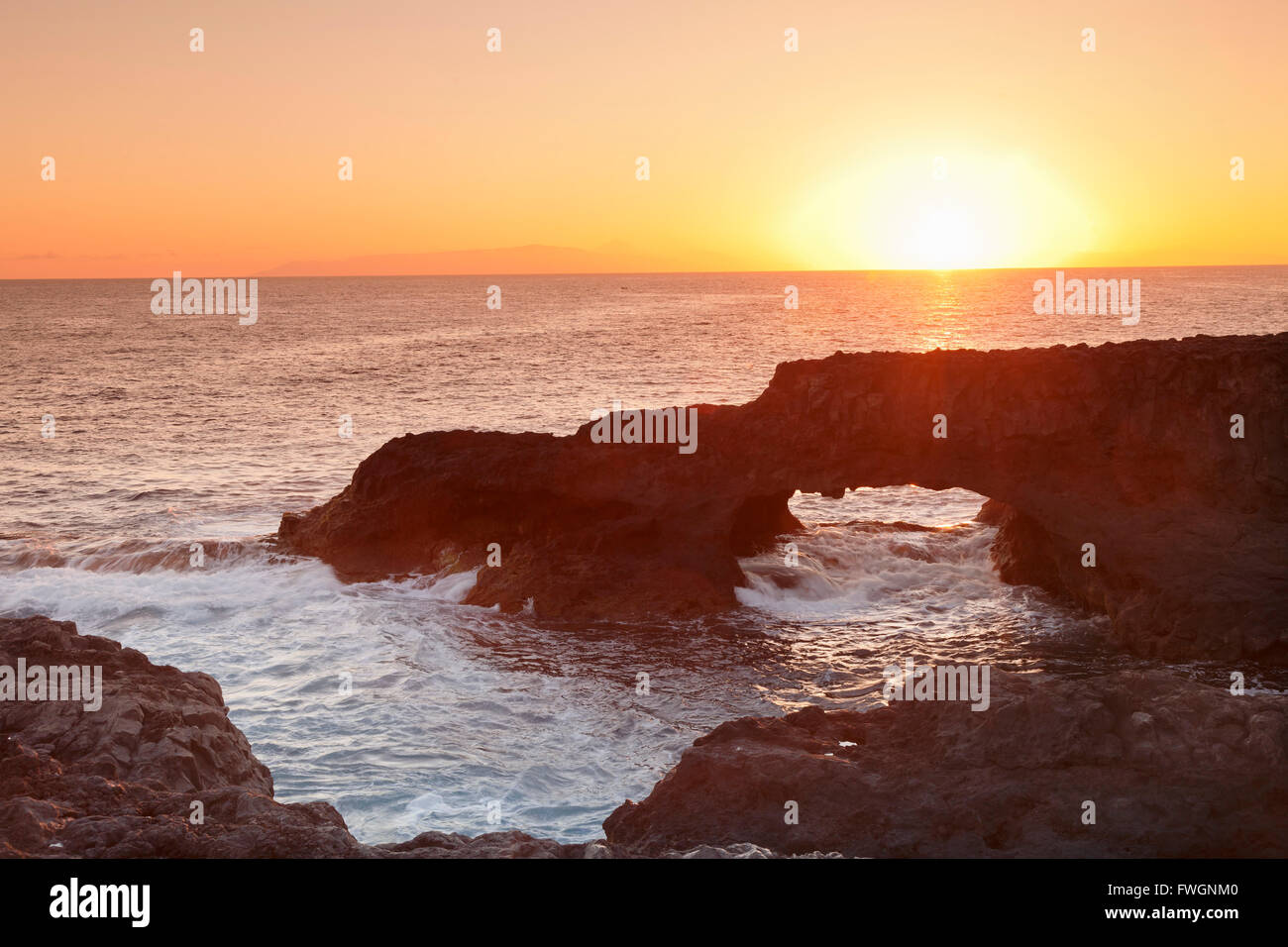 Arco di roccia di sunrise, Charco Manso Bay, Punta Norte vicino Echedo, UNESCO Riserva della biosfera di El Hierro, Isole Canarie, Spagna Foto Stock