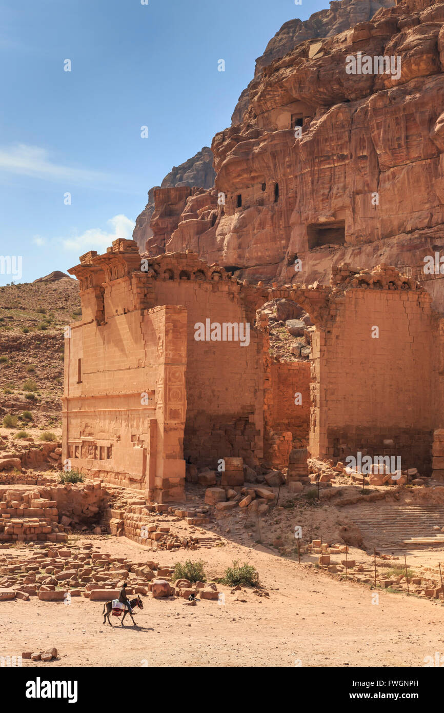 Uomo locale su donkey passa Qasr al-Bint tempio, vista in elevazione, città di Petra rovine, Petra, Sito Patrimonio Mondiale dell'UNESCO, Giordania Foto Stock