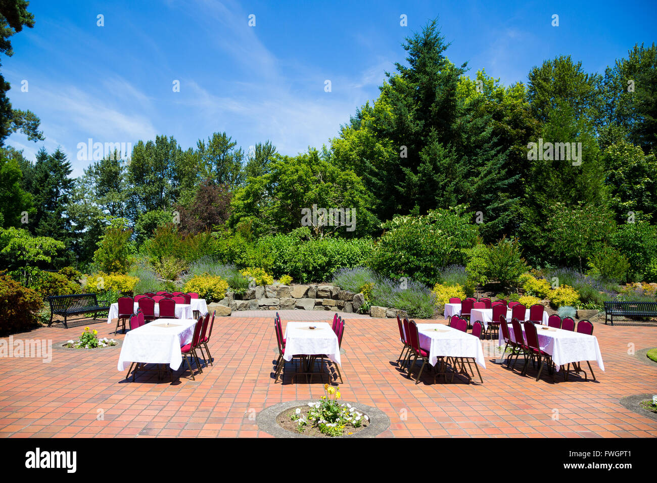 Alcuni tavoli e sedie sono impostate su Pronto per un ricevimento di matrimonio non appena la cerimonia è finita all'aperto in Oregon a un parco. T Foto Stock