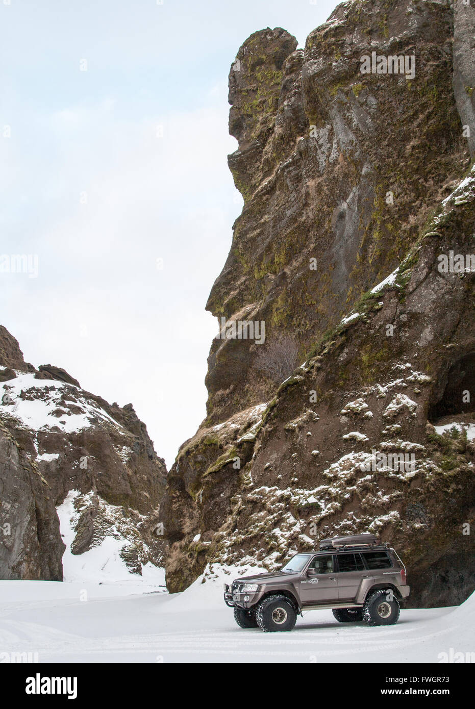 Nissan Patrol superjeep parcheggiato a fianco di scogliere rocciose circondato da neve, Thorsmork in inverno Foto Stock